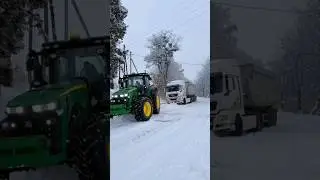 John Deere at full power to remove truck stuck in snow.