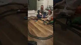 Dad and son build a large lego train set and have to wave everytime train goes past