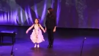Lana performing on stage with Cara Braia singing Popular.