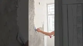 smoothing wet wall plaster using flat trowel moving hand slowly evenly across surface daily work