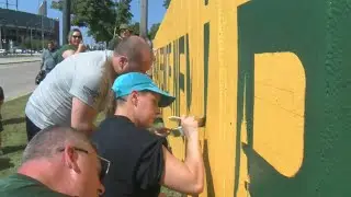 Packers fans continue tradition, paint new slogan on the Original Packer Fence