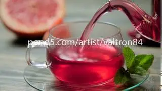 Pouring red tea from a teapot into a cup on a wooden table. Close up