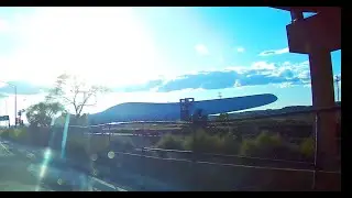 Driving on historic Route 66 during evening sunset next to Railroad Train Huge Wind Turbine Blades