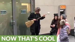 Street performer turns broom into electric guitar