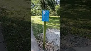 Disc golf hole number 5 sign on a wooden post at a park in Fall Autumn.