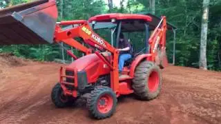 Kubota M59 backhoe moving metal carport