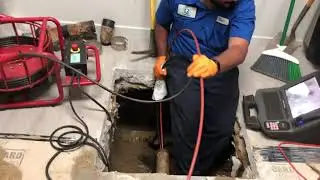 Cleaning all the scale from the old cast iron drain pipes under concrete slab.