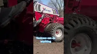 Ventrac spreading soil before aerating, seeding, and using a lawn drag