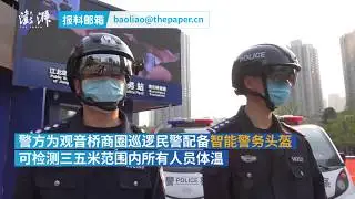 Chongqing police officers wear smart helmets to view real-time body-temperatures of passers-by
