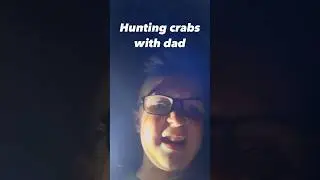 Father and son crab adventure on the beach at night