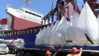 Transshipment of goods at the seaport. Unloading of a cargo ship. Big Run bags.