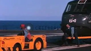 SH-3A helicopters loaded with homing torpedoes are hooked up with tractors aboard...HD Stock Footage