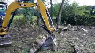 Mini Digger Hydraulic Grab being use to lift a heavy stone block