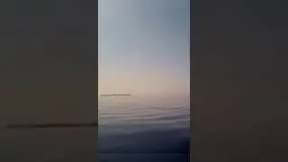 An Idiot on an traditional boat in the maldives-flat ocean-islands in the distance-nature-no waves