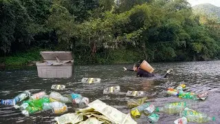 Poor girl picking up trash saw a Styrofoam box floating on the water - Daily life collecting scrap