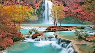 A relaxing video of a beautiful turquoise waterfall cascading down into crystal clear pools surround