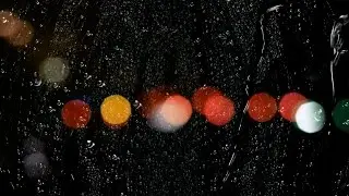 Rain Drops on Window Glass,Bokeh Lights Traffic Lights in Background