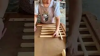 Hands assemble wooden lattice, evenly spaced slats form precise grid structure.