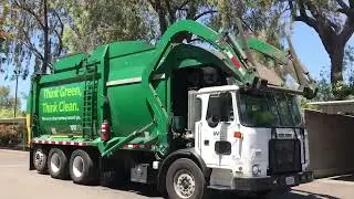 Front Loading Garbage Truck Picking Up Dumpsters At An Apartment Complex