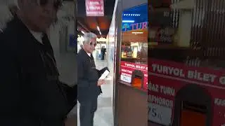 PURCHASING TICKETS FOR THE FERRY TO TAKE US FROM THE ASIAN SIDE OF ISTANBUL TO THE EUROPEAN SIDE.