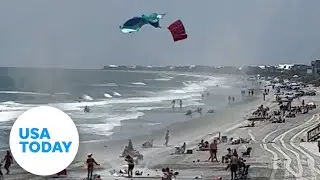 Dust devil swirls on a busy beach, sending towels flying in the air | USA TODAY