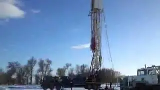 Workover rig derrick folds in half