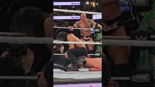 Roman Reigns wrenching Seth Rollins knee as The Rock looks on