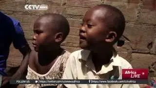 Ugandan youth sheltering orphaned children