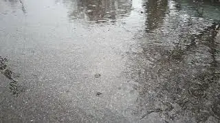 slow motion full-frame view of wet asphalt under rainfall