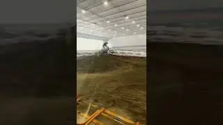 Dirt bike rider indoors track old air plane hanger