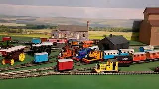 Bachmann Rusty pulling 4 brown 3 grey slate wagons, blue box van and red brakvan 