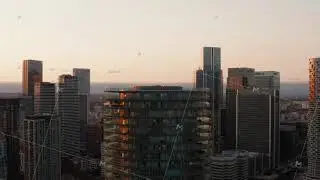 Slide and pan footage of top of Baltimore Tower. Cylindrical apartment building with terraces on
