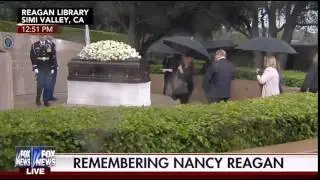 Woman takes a picture with Nancy Reagan's casket