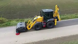 Koparko ładowarka Stroer C 799T praca ze szczotką z kolektorem oraz zraszaczami.