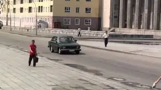 A Volvo 144 passing the Kim Il Sung square in Pyongyang