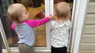 Близнецы учатся качаться на качелях вместе.