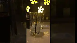 a mostly empty glass of water in a crowded restaurant on a saturday night
