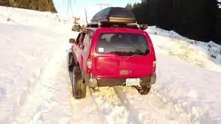 Red Nissan Xterra snow fun followed by DJI mavic mini 2