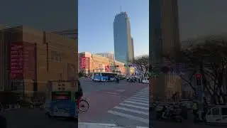 China | A busy intersection with a landmark in the background.