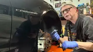 Removing the dirt & grease from the passenger side front disc brake assembly 