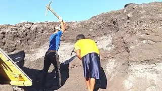 With A Hoe, The Miner Breaks Down Chunks Of Solid Sand