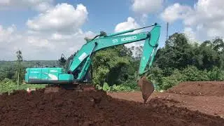 Excavator Kobelco SK200 Digging and Moving Red Dirt
