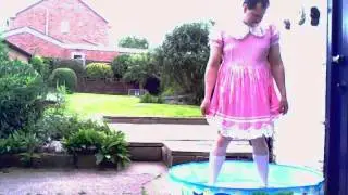 sissy baby playing in paddling pool in nappy and dress