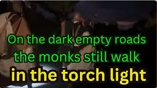 On the dark empty roads the monks still walk in the torch light