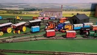 Bachmann Yellow Rheneas pulling 1 brown, 1 red, 1 grey slate wagons and blue box van 