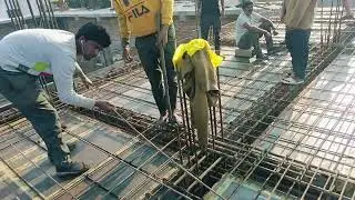 The mason is working on tying the reinforcement bars for the roof 