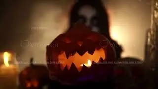 Woman with santa muerte makeup holding pumpkin and moves it forward