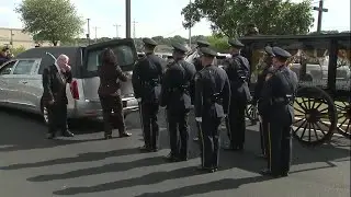 Officer Moreno's casket placed in horse-drawn carriage