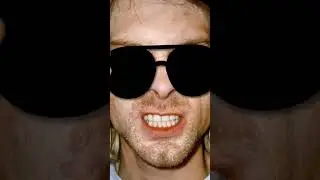 An angry Kurt Cobain putting on sunglasses.