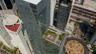 High angle view of tall modern glass cover building. Drone camera flying around Paradox Torre